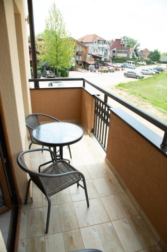 a balcony with a table and chairs and a view of a street at Apartmani borova 2 in Veliko Gradište