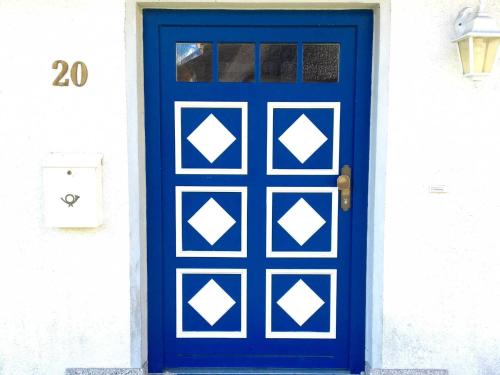 una puerta azul en una casa blanca en Haus Ketzenberg 1 - Lütt Mööv, en Groß Zicker