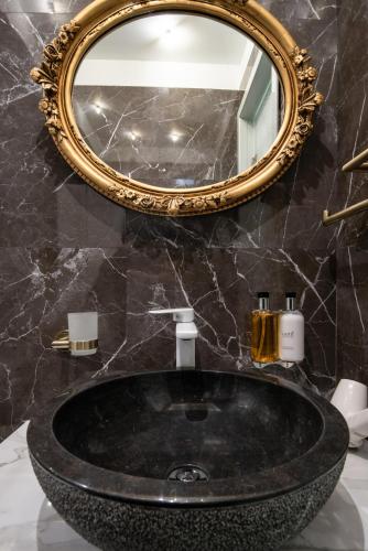 a bathroom with a black sink and a mirror at Pela Veranda Exquisite Suites in Neos Marmaras