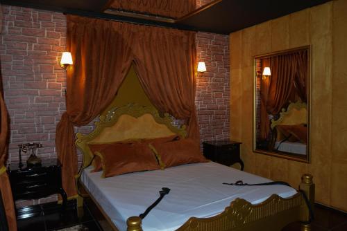 Un dormitorio con una cama en una pared de ladrillos. en Amore Mio (Adult Only), en Gramado