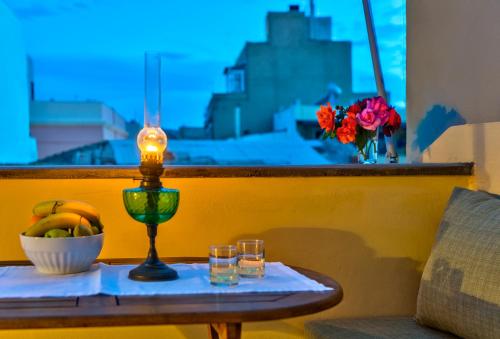 a table with a candle and glasses on a balcony at Island of Luxury Apartments in Ermoupoli