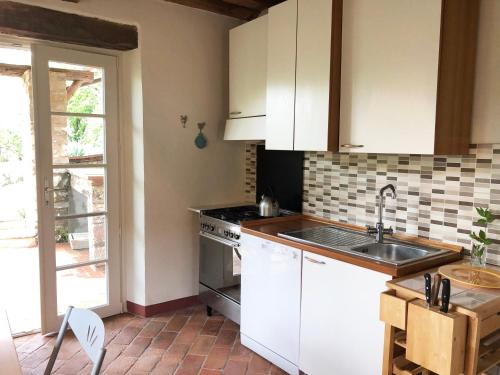 uma cozinha com armários brancos e um lavatório em Il Capriolo em Lucca