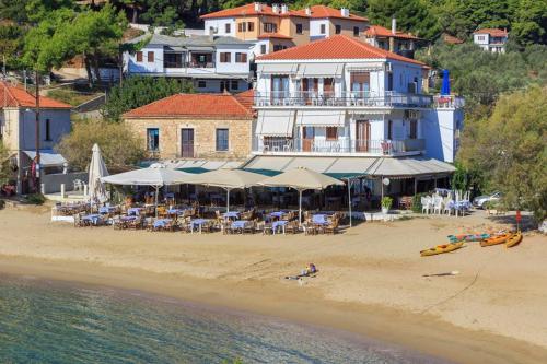 a hotel on a beach with chairs and umbrellas at VOULGARIS in Agios Georgios