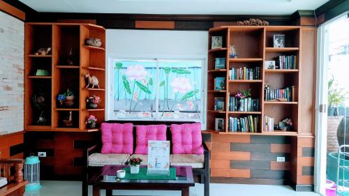 a living room with a couch and bookshelves at Ruen Buathong Boutique Hotel Patong Beach in Patong Beach