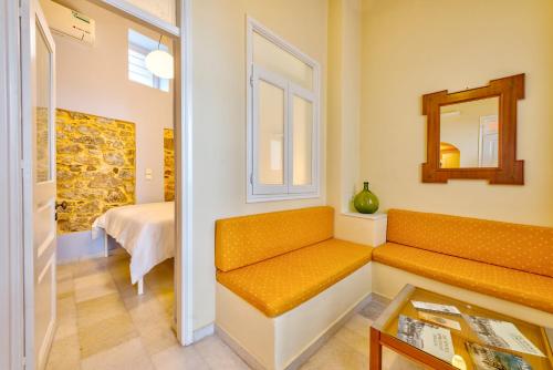 a room with a bench and a bed and a mirror at Island of Luxury Apartments in Ermoupoli