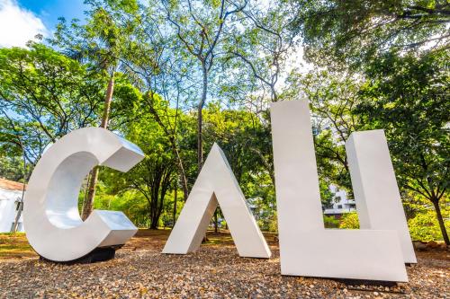 a large white sign with trees in the background at Sonesta Hotel Cali in Cali