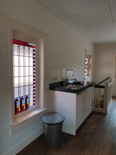 a kitchen with a sink and a counter and a window at Studio in Stijl in Apeldoorn