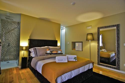 a bedroom with a bed and a large mirror at RH Casas de Campo Design in Parada