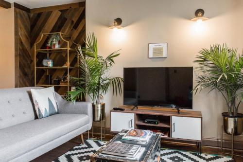 a living room with a couch and a flat screen tv at Villa Dubois Guest House in Chicago