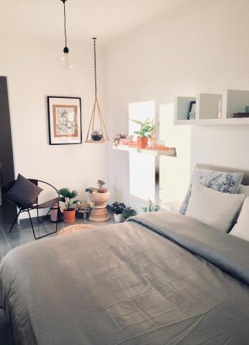 - une chambre avec un lit, une chaise et des plantes dans l'établissement Deluxe Penthouse Charming Location Rooftop Views, à Marsaxlokk