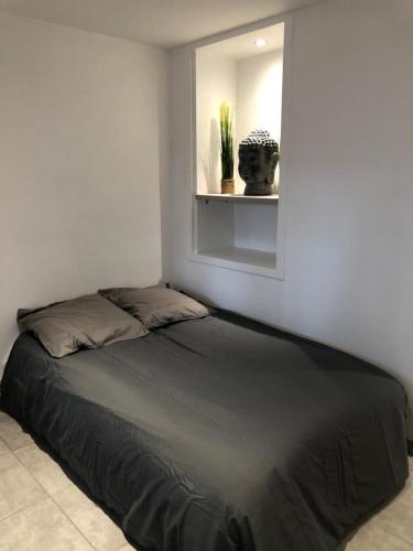 阿格德角appartement Cap d’Agde的卧室内的一张床位,卧室设有窗户和架子