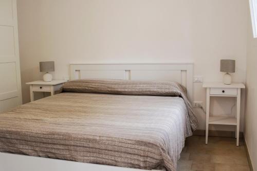 - une chambre avec un grand lit et 2 tables de chevet dans l'établissement Casa del mare, à Capitolo