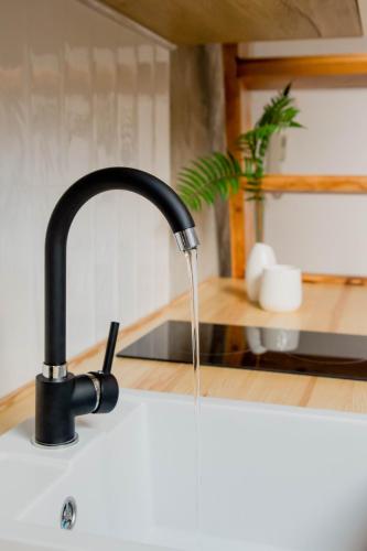 a kitchen sink with water running from a faucet at Skyway Apartment in Toruń