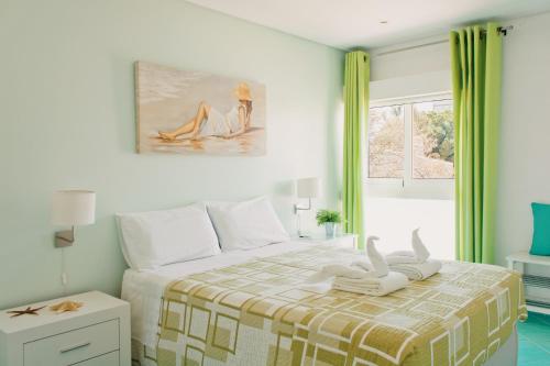Un dormitorio con una cama con dos cisnes. en Quinta Do Romao, Vilamoura, en Quarteira