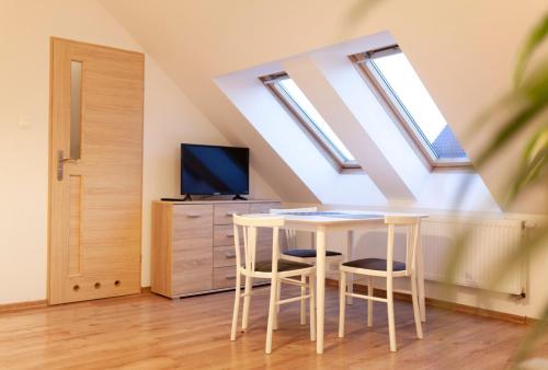 a dining room with a table and two stools at North Pokoje Gościnne in Swarzewo