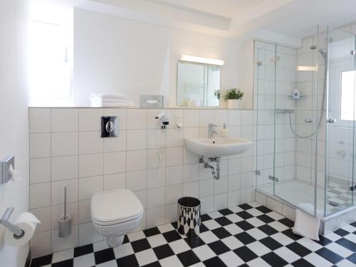 ein Bad mit einem WC, einem Waschbecken und einer Dusche in der Unterkunft Hotel Karolinger Hof in Lorsch