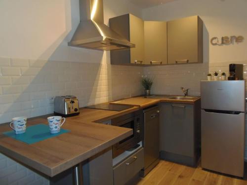 a kitchen with a counter top and a refrigerator at Le jardin des Lices in Toulon
