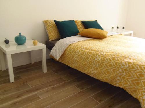 een slaapkamer met een bed en een witte tafel met een nachtkastje bij Le jardin des Lices in Toulon