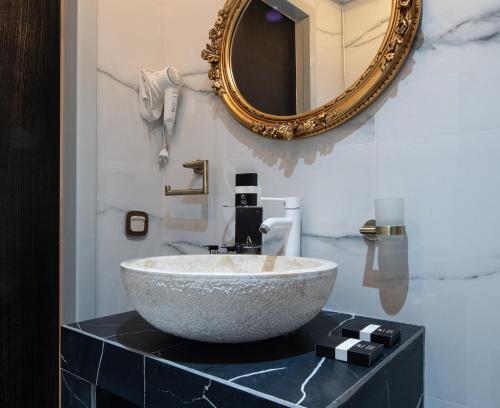 a bathroom with a bowl sink and a mirror at Pela Veranda Exquisite Suites in Neos Marmaras
