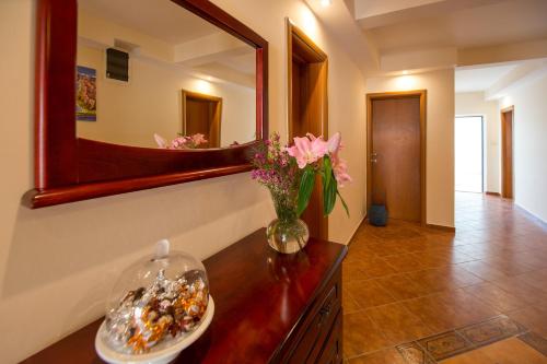 a bathroom with a vase of flowers and a mirror at Villa DiEden in Budva