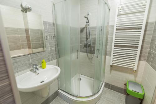 a white bathroom with a sink and a shower at Willa Nova in Polańczyk