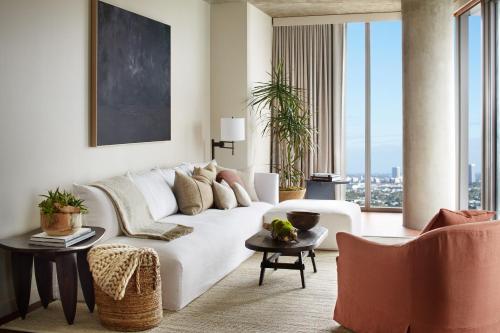 a living room with a white couch and large windows at 1 Hotel West Hollywood in Los Angeles