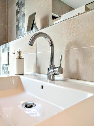 a white sink with a faucet in a bathroom at Friesenbude Deluxe in Jever