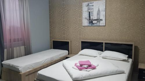 dos camas con una flor rosa encima de ellas en Vila Fara Nume, en Mamaia Nord – Năvodari
