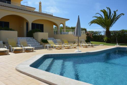 une villa avec une piscine en face d'une maison dans l'établissement Villa Paraiso - 4 Bedrooms and pool, à Albufeira