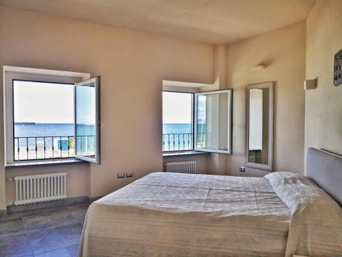 a bedroom with a bed with a view of the ocean at Appartamento deluxe con terrazza sul mare in Savona