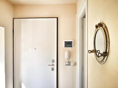a bathroom with a white door and a mirror at Appartamento deluxe con terrazza sul mare in Savona