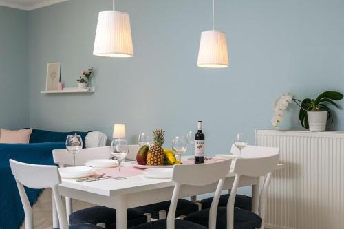 a white table with white chairs and wine glasses at Casa di Emma in Néa Péramos