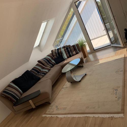 a large couch in a living room with windows at Comfort Lodging Stueckenfeld in Hannover