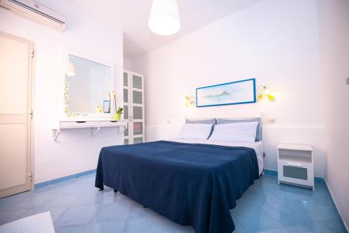 sypialnia z łóżkiem z niebieskim kocem w obiekcie Le Querce w mieście Procida