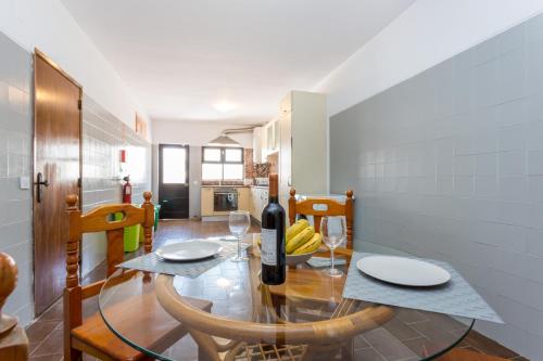 a dining room with a table with a bottle of wine at Safari Beach guest house in Lagos
