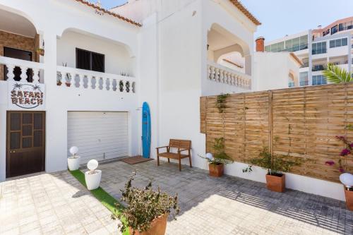 a courtyard in a white house with a wooden fence at Safari Beach guest house in Lagos