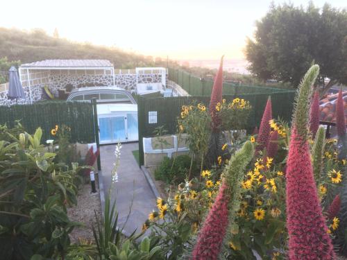 a garden with colorful flowers and a fence at Casa Rural Finca Paraíso. Heated pool in Vilaflor