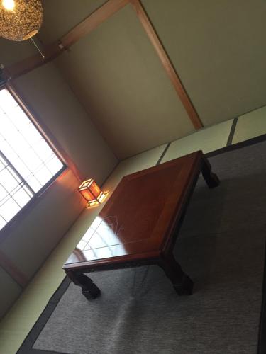 a wooden bench in a room with a window at Guest house daisho oshiro asobi in Matsue