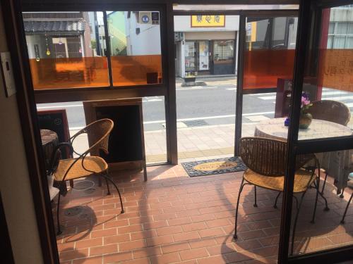 a view of a table and chairs from a window at Guest house daisho oshiro asobi in Matsue