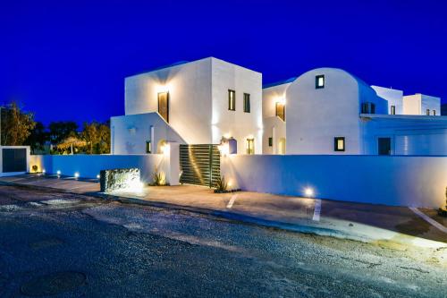 a large white house at night with lights at Sun Springs Suites in Kamari