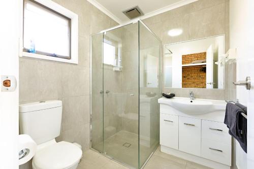 a white toilet sitting next to a bath tub at Statesman Motor Inn in Corowa