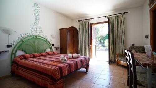a bedroom with a bed with a cat sitting on it at Residenza Su Prelau in Gonnesa