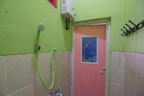 - Baño con ducha y puerta rosa en RedDoorz near Kampus UMP Purwokerto, en Purwokerto