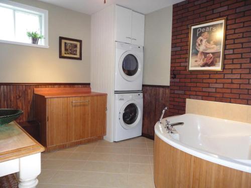 a bathroom with a washing machine and a washer and dryer at Le 154 Jacques-Cartier in Gaspé