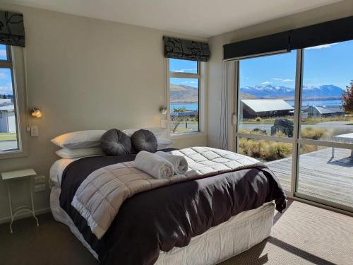 um quarto com uma cama grande e uma janela grande em Loch View - Lake Tekapo em Lake Tekapo