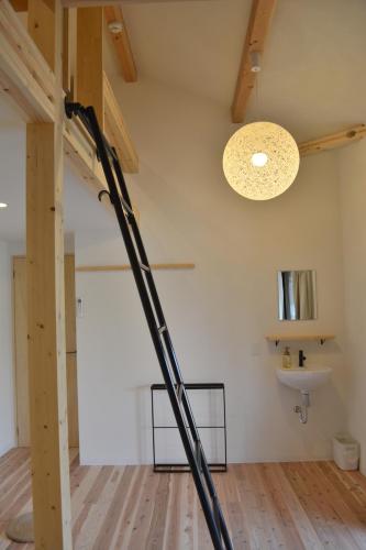 a large black pole in a room with a sink at BED N CHILL Shippoya 七宝屋 in Mitoyo