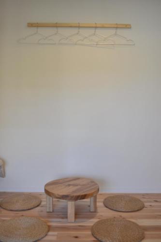 a coffee table and stool in front of a wall at BED N CHILL Shippoya 七宝屋 in Mitoyo