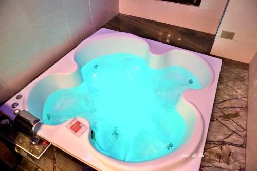 a bath tub filled with blue water in a bathroom at Puli Story House in Puli