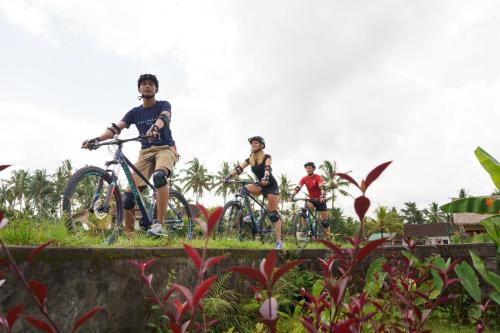a group of people riding bikes on a bridge at Tejaprana Bisma - CHSE Certified in Ubud