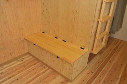 a wooden bench in a room with a wooden floor at BED N CHILL Shippoya 七宝屋 in Mitoyo
